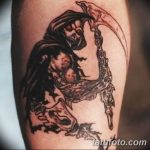 Фото татуировки Жнеца в стиле blackwork на руке. Черно-белый рисунок с косой, капюшоном и брызгами. Идеи для тату.