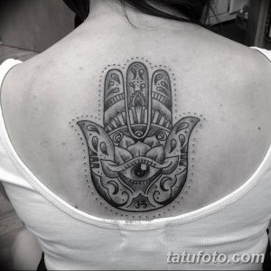 Фото тату на спине: рука Фатимы с глазом в центре, выполненная в технике blackwork. Детализированный рисунок татуировки.