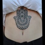 Фото крупной татуировки Хамса на спине. Черно-белый рисунок с высокой детализацией, выполненный в стиле дотворк. Идеально подходит для тех, кто ищет идеи для масштабных татуировок.