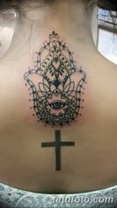 Фото тату Хамса и крест на груди, выполненная в технике blackwork. Композиция сочетает в себе религиозный и защитный символы.