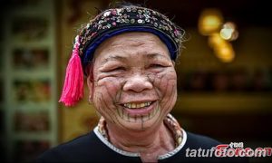 Фото тату: портрет пожилой женщины с традиционными татуировками на лице. Татуировки выполнены черными линиями.