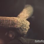 Фото тату: рука мужчины, полностью покрытая черными полинезийскими узорами. Сложные геометрические формы и символы создают впечатляющий рисунок.
