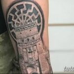 Фото тату: реалистичная татуировка башни на руке мужчины, выполненная в черно-серых тонах с высокой детализацией.