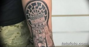 Фото тату: реалистичная татуировка башни на руке мужчины, выполненная в черно-серых тонах с высокой детализацией.