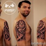 Фото тату: полинезийский орнамент на плече и предплечье мужчины, выполненный в черном цвете, с детальной проработкой узоров.