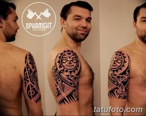Фото тату: полинезийский орнамент на плече и предплечье мужчины, выполненный в черном цвете, с детальной проработкой узоров.