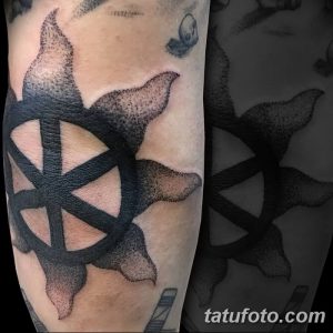 Фото татуировки в виде пятиконечной звезды, выполненной в технике dotwork на локте, с использованием черных точек различного размера.