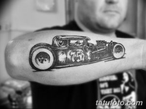 Фото тату хот-рода (hot rod) в черно-белом графическом стиле на предплечье. Рисунок выполнен с использованием четких линий и штриховки.