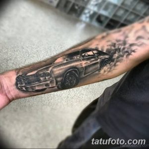 Фото тату автомобиля, выполняющего дрифт, с клубами дыма, выполненное в черно-белой гамме на руке.
