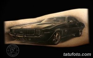 Фото тату черного Camaro 1969 года на предплечье, выполненное в реалистичном стиле с использованием теней и бликов.