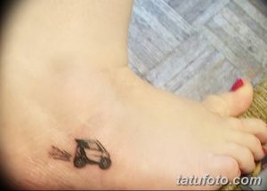 Фотография небольшой татуировки автомобиля на женской стопе. Черно-белый рисунок, минималистичный стиль, аккуратные линии.