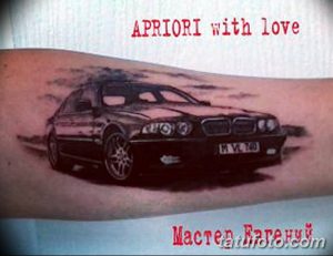 Фото тату на руке: реалистичное изображение автомобиля BMW E39 серого цвета, с прорисованными деталями и отражениями.