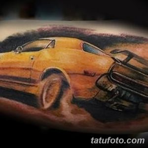Фото тату: желтый Ford Mustang на руке, выполненный в реалистичном стиле, детализированный рисунок татуировки.