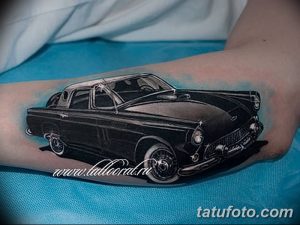 Фото тату: стильный черно-белый рисунок классического автомобиля на предплечье, выполненный в реалистичном стиле с высокой детализацией и светотенью.