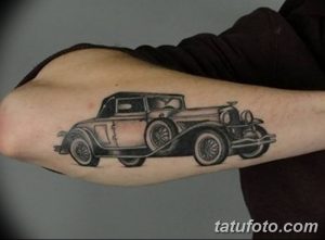 Фото тату: стильный черно-белый рисунок старинного автомобиля на предплечье, выполненный в графическом стиле с четкими линиями и деталями.