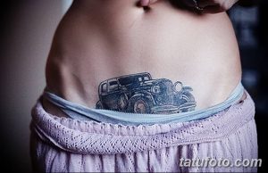 Фото тату: небольшой рисунок старинного автомобиля на животе, выполненный в черно-серых тонах, с акцентом на детали и винтажный стиль.