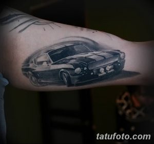 Фото тату: реалистичный черно-белый рисунок Ford Mustang на руке, выполненный с использованием теней и полутонов для создания эффекта объема.