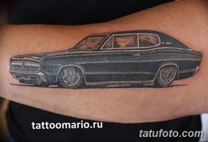 Фотография черно-белой татуировки классического автомобиля на руке. Детализированный рисунок в стиле реализма.