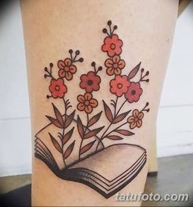 Яркое фото татуировки на ноге с изображением открытой книги, из которой растут красные цветы в стиле олдскул.