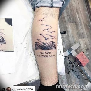 Фото тату: стопка книг, летящие страницы и фраза 'I've lived a thousand lives' на ноге, выполненное в черно-серых тонах.