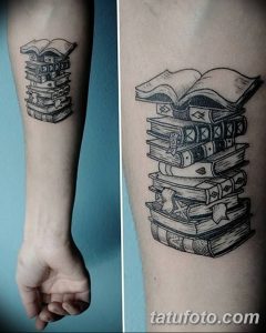Черно-белое фото татуировки на руке с изображением стопки книг. Рисунок выполнен в классическом стиле с четкими линиями и деталями.