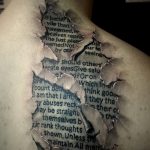 Фотография реалистичной татуировки на руке, имитирующей рану с выходящим текстом. Рисунок выполнен в черно-серых тонах с высокой детализацией.