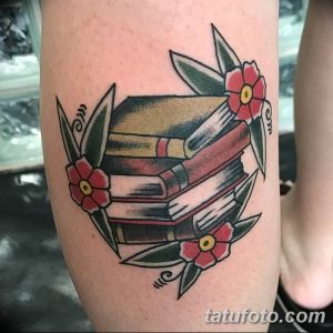 Классическая татуировка в стиле олдскул на руке: стопка книг, украшенная красными цветами и зелеными листьями. Идеи для ярких и традиционных тату.