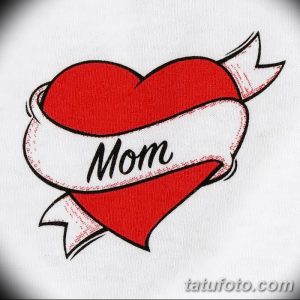Фото татуировки с надписью 'Mom' внутри красного сердца, украшенного лентой. Простой и эмоциональный дизайн для выражения любви к матери.