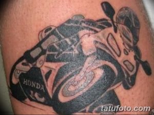 Фото тату мотоцикла Honda, выполненного в стиле old school с использованием черных и серых оттенков. Татуировка на руке.