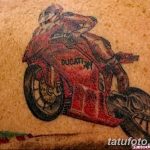 Фото тату: яркий рисунок красного мотоцикла Ducati 749, выполненный на коже с добавлением элементов трассы.