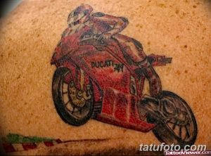 Фото тату: яркий рисунок красного мотоцикла Ducati 749, выполненный на коже с добавлением элементов трассы.