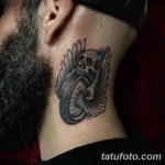 Фото тату: простая черно-белая татуировка черепа с крыльями и мотоциклетного колеса, выполненная на шее.