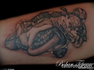 Фото тату: детализированная черно-серая татуировка мотоциклиста в футуристическом стиле киберпанк, с механическими элементами и сложной детализацией.