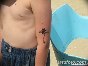Фото минималистичной татуировки ската, выполненной черными линиями на руке. Простой и лаконичный дизайн.