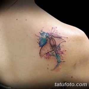 Фото нежной акварельной татуировки ската на ключице. Рисунок с размытыми красками в голубых и розовых тонах.
