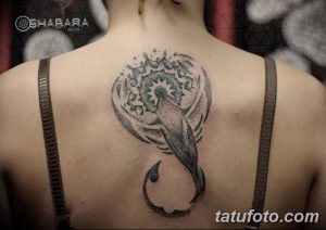 Фото татуировки ската в стиле дотворк с добавлением акварельных элементов на спине девушки. Черно-серый рисунок с точками и размытыми красками.