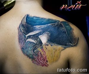 Фото тату: красочная акварельная татуировка ската на спине, с изображением кораллов и морских водорослей.