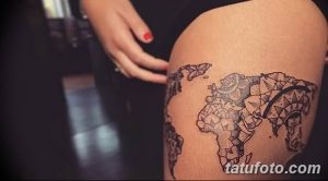 Фото тату карты мира на бедре, выполненной в геометрическом стиле с использованием тонких черных линий и треугольников. Подходит для любителей современного искусства.