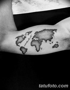 Фото тату: карта мира и надпись "wanderlust", выполненные в технике дотворк на предплечье. Стильный рисунок татуировки.