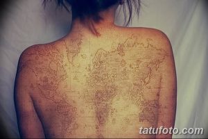 Фото тату: большая татуировка в стиле старинной карты мира на спине, выполненная в коричневых и бежевых тонах.