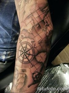 Фото тату на предплечье: карта мира с компасом, выполненная в технике blackwork. Детализированный рисунок татуировки с элементами старинной картографии.