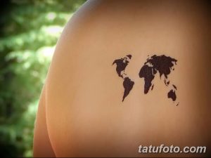 Фото тату: простая карта мира, выполненная черным цветом на плече. Изображение выглядит как силуэт континентов, без лишних деталей.