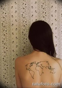 Фото тату: изящная карта мира на спине девушки, выполненная в виде тонких линий. Минималистичный и женственный дизайн.