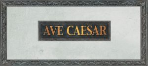 Фото татуировки с надписью 'Ave Caesar' в декоративной рамке. Использованы золотистые и серые оттенки, создающие эффект старины. Расположение - предположительно, на спине.