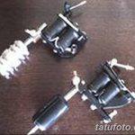 Фотография двух тату-машинок разных моделей, расположенных на деревянной поверхности. Идеально для сравнения старых и новых технологий в тату-индустрии.