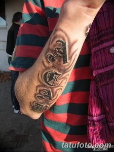 Фото татуировки на руке в стиле blackwork: надпись A.C.A.B. с острыми углами и черными линиями. Минималистичный рисунок татуировки.