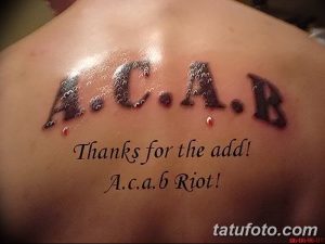 Фото татуировки на спине: надпись A.C.A.B. с эффектом капель крови и дополнительным текстом. Оригинальный рисунок татуировки.