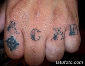 Фото тату надписи ACAB на костяшках пальцев руки. Черно-белый рисунок татуировки, выполненный в минималистичном стиле.