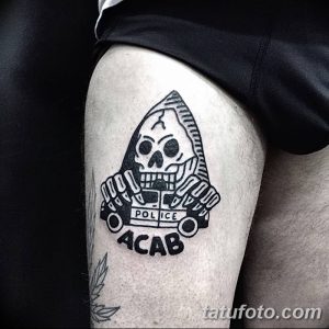 Фото тату с изображением черепа в полицейском шлеме и надписью 'ACAB'. Черно-белая татуировка, выражающая протест и бунтарский дух.