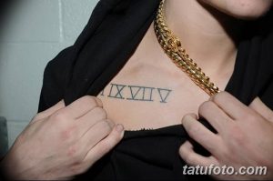 Фото тату: простая татуировка с римскими цифрами XIVIV на груди. Лаконичный и стильный дизайн для тех, кто ценит минимализм.